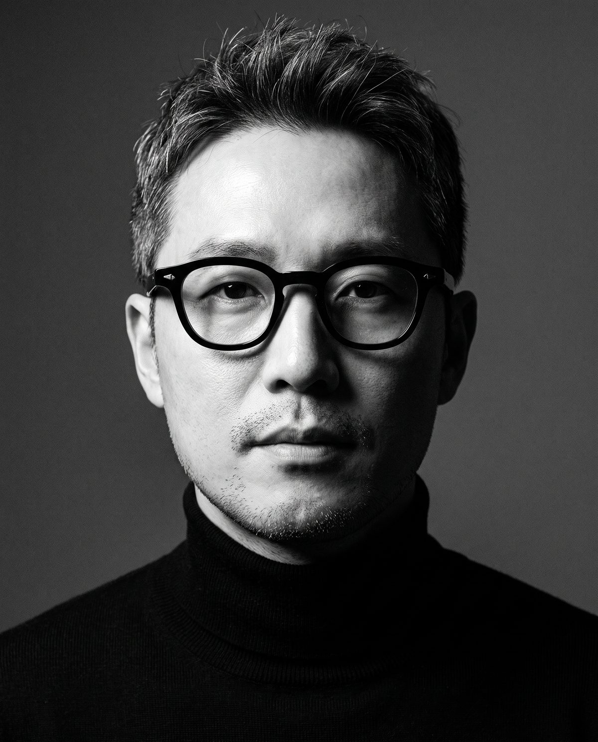 검은 터틀넥에 RETRO-1 블랙을 쓴 남자의 흑백 초상